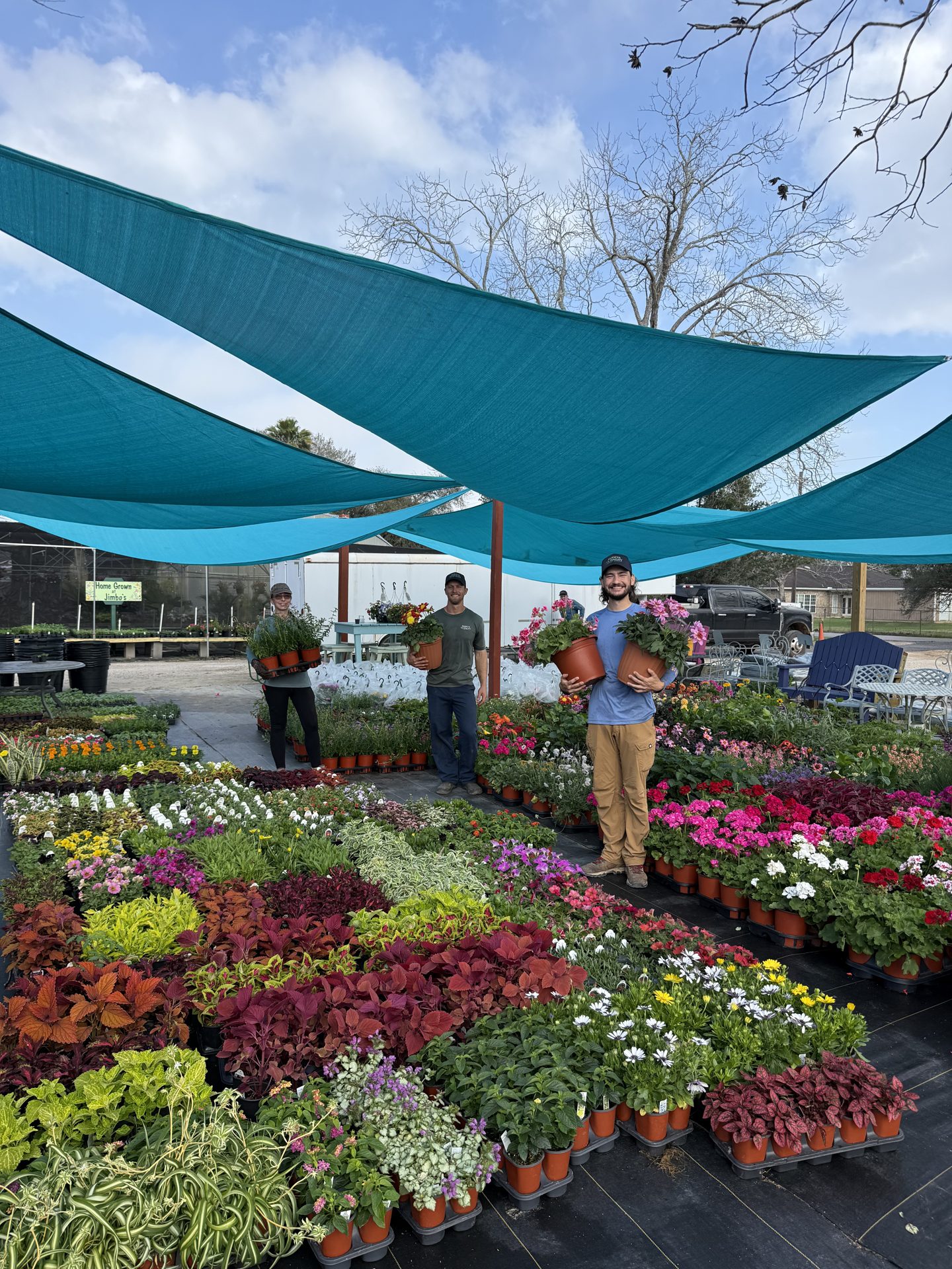 The Jimbo’s team holding plants in the yard